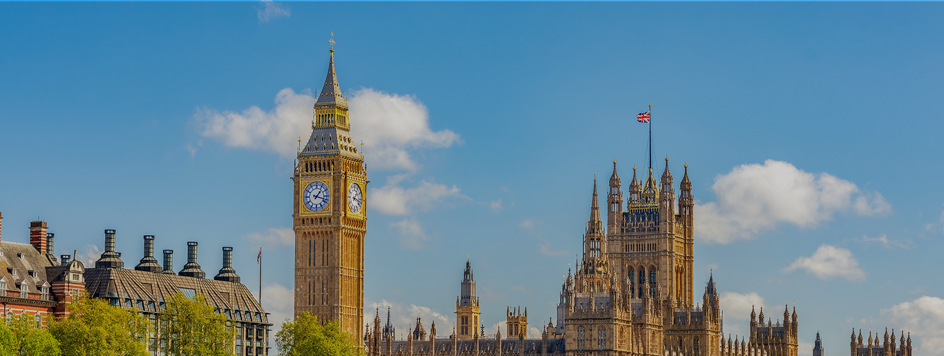The Houses of Parliament and Big Ben in London on a sunny day, with a blue sky and a few clouds in the background—perfect for travelers arriving from WallyPark Airport Parking to explore the city’s iconic sights.